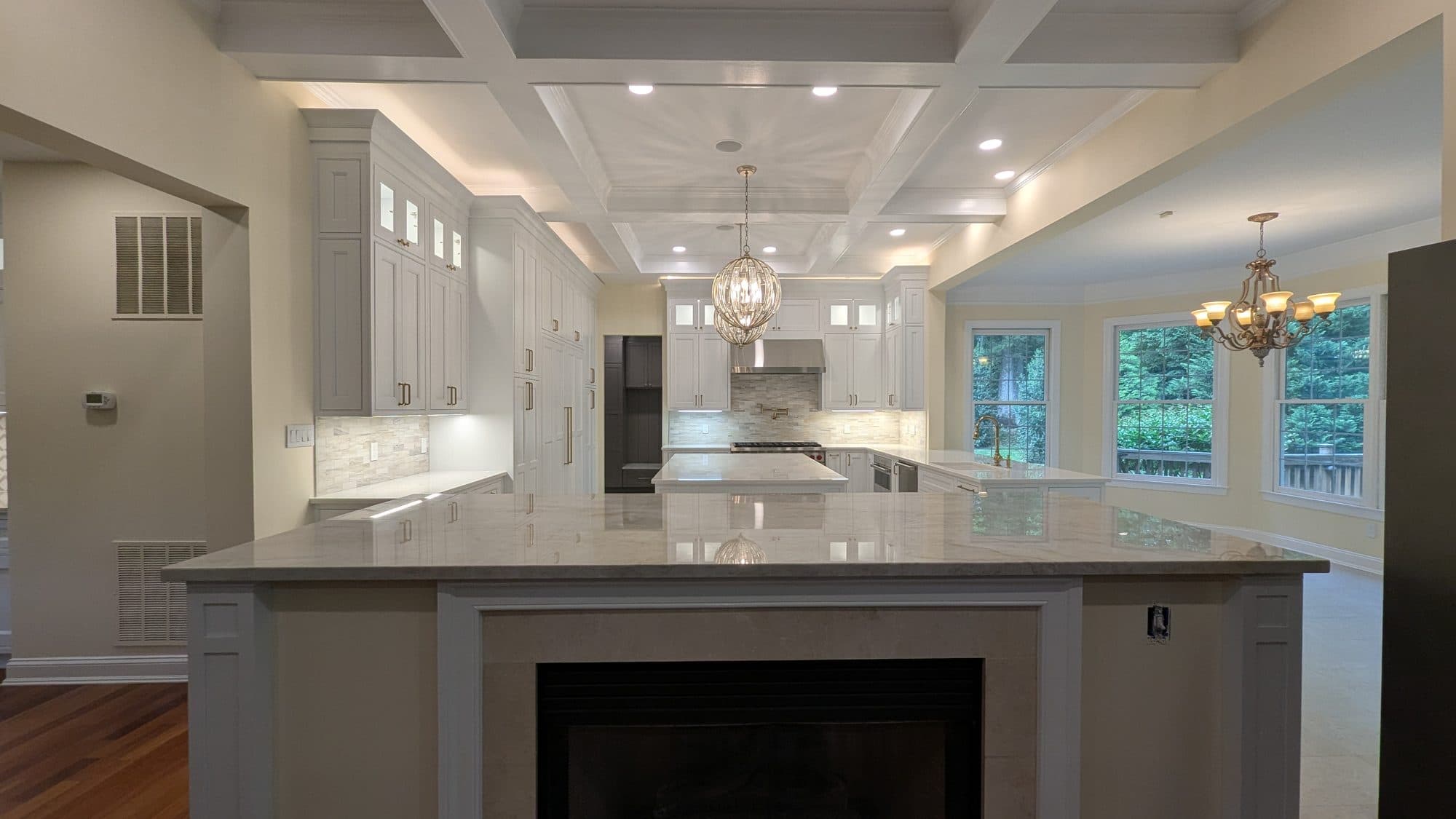 Kitchen with glass-front cabinetry, stone backsplash, and crystal orb pendant lighting over the island